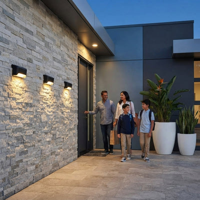 Four solar motion sensor lights mounted on a modern exterior wall, illuminating a home entrance at dusk.